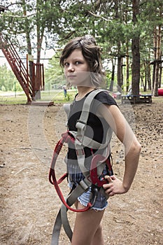 Girl in safety equipment in rope park . ÃÂ¡limbing adventure park photo